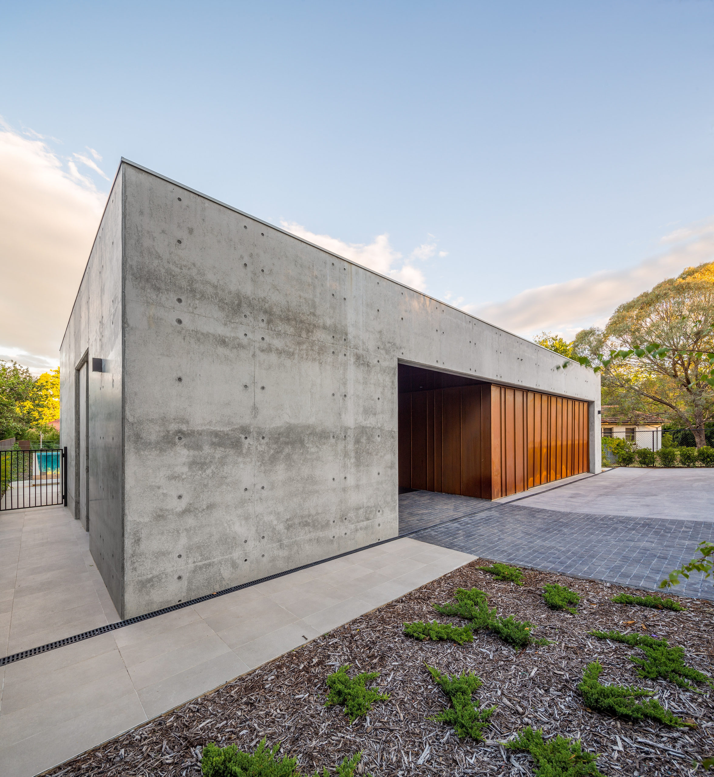 An amazing house frontage with copper garage door and off form concrete walls